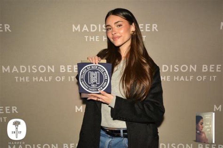 Madison Beer holding a sign